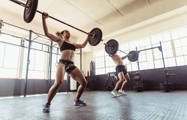 Fitness Menschen im Fitnessstudio Durchführung deadlift Übung mit Gewicht bar. Mann und Frau tun Gewichtheben Übungen im Fitnessstudio. - JLPSF02052