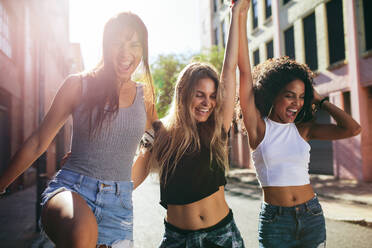 Three young women walking together having fun. Multi ethnic female friends walking outdoors in city. - JLPSF02076