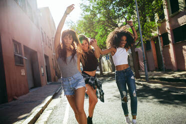 Außenaufnahme von schönen jungen Frauen, die sich auf der Straße amüsieren. Mehrrassige Freundinnen, die einen Tag in der Stadt genießen. - JLPSF02078