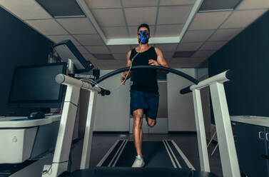 VO2-Max-Test: Ein fitter junger Mann, der mit einer Maske schnell auf dem Laufband läuft. Ein Sportler, der seine Leistung im sportwissenschaftlichen Labor überprüft. - JLPSF02084