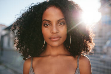 Close up Porträt der schönen jungen afrikanischen Frau mit lockigem Haar. afroamerikanische Frau steht im Freien. - JLPSF02116