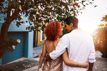 Romantisches junges Paar, das sich auf einer verlassenen Straße umarmt. Ein junger Mann und eine junge Frau stehen dicht beieinander und schauen sich zum Ausdruck ihrer Liebe an. - JLPSF02128