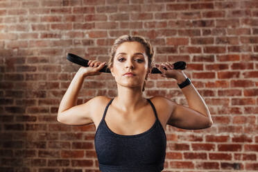 Athletic young woman after hard workout at gym. Fitness girl holds