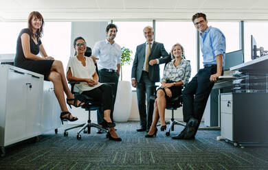 Full length portrait of successful business people looking at camera and smiling. Businessman and businesswoman together in office. - JLPSF02292