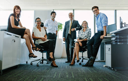 Ganzkörperporträt von erfolgreichen Geschäftsleuten, die in die Kamera schauen und lächeln. Geschäftsmann und Geschäftsfrau zusammen im Büro. - JLPSF02292