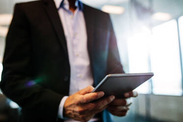 Close up of male hands using digital tablet in office. Businessman man hand using tablet device. - JLPSF02366