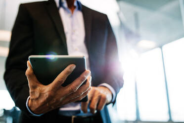 Cropped shot of businessman working on digital tablet in office. Close up of male hands holding tablet pc. - JLPSF02367