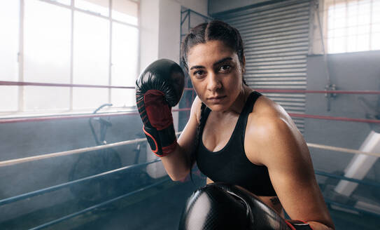 Eine weibliche Boxerin übt ihre Bewegungen in einem Boxstudio. Nahaufnahme einer weiblichen Boxerin beim Schattenboxen in einem Boxring. - JLPSF02392
