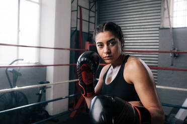 Nahaufnahme einer weiblichen Boxerin beim Schattenboxen in einem Boxring. Eine Boxerin übt ihre Schläge in einem Boxstudio. - JLPSF02396
