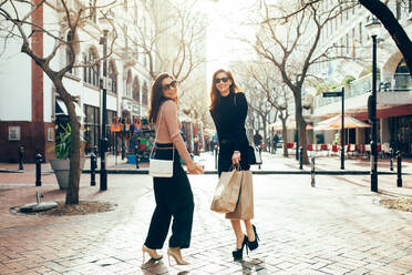 Happy friends shopping. Full length of two beautiful young women enjoying shopping in the city. - JLPSF02426