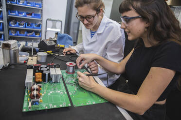 Ingenieure beim Zusammenlöten von Leiterplatten in der Elektronikindustrie - PCLF00028