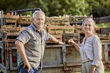 Lächelnde Landwirte vor einem Lastwagen mit einer Kiste Weintrauben - ZEDF04891