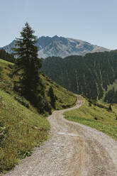 Schweiz, Kanton Graubünden, Kurvenreicher Wanderweg in den Samnauner Alpen mit dem Piz Mundin im Hintergrund - DMGF00849