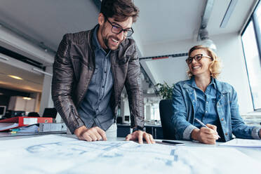 Geschäftspartner arbeiten im Büro zusammen. Zwei Architekten arbeiten an einem Bauplan. - JLPSF02473