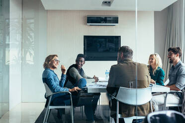 Female manager leads brainstorming meeting in design office. Businesswoman in meeting with colleagues in conference room. - JLPSF02529