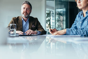 Serious businessman in meeting with colleagues in office. Businesspeople during business presentation in conference room. - JLPSF02532