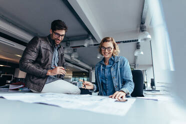 Architektenteam bei der Arbeit an einem Bauplan. Geschäftskollegen arbeiten im Büro zusammen. - JLPSF02667