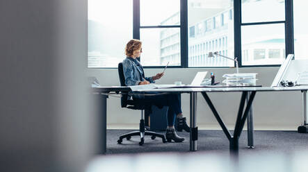 Young businesswoman with digital tablet working at her desk. Female designer working in office. - JLPSF02680