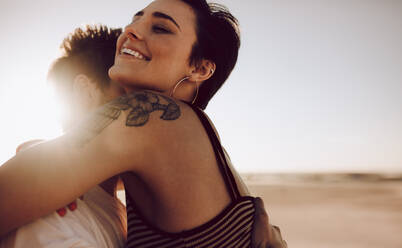 Attractive young woman embracing her boyfriend outdoors. Romantic young couple outdoors on a summer day. - JLPSF02778