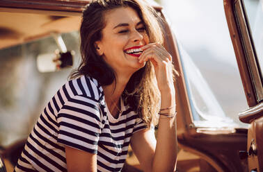 Portrait of pretty young woman sitting in a car and smiling. Woman having fun on the road trip. - JLPSF02797