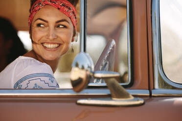 Schöne Frau, die aus dem Fenster schaut, während sie Auto fährt. Frau mit Freunden auf Road Trip. - JLPSF02816