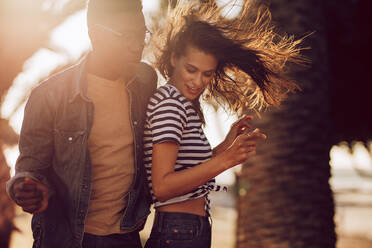 Young man and woman dancing outdoors on a summer day. Couple of friends dancing outdoors. - JLPSF02858