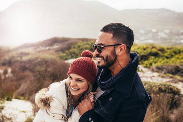 Happy loving couple laughing and embracing at the beach. Couple spending time on a winter day. - JLPSF02953