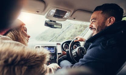 Happy young couple on road trip. Man driving car with female sitting by. - JLPSF03048