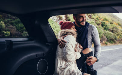 Glückliches junges Paar auf dem Rücksitz eines Autos. Romantisches junges Paar auf einer Autoreise. - JLPSF03065