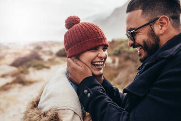 Close up of loving couple in warm clothing outdoors. Smiling man and woman enjoying a winter day at the beach. - JLPSF03095
