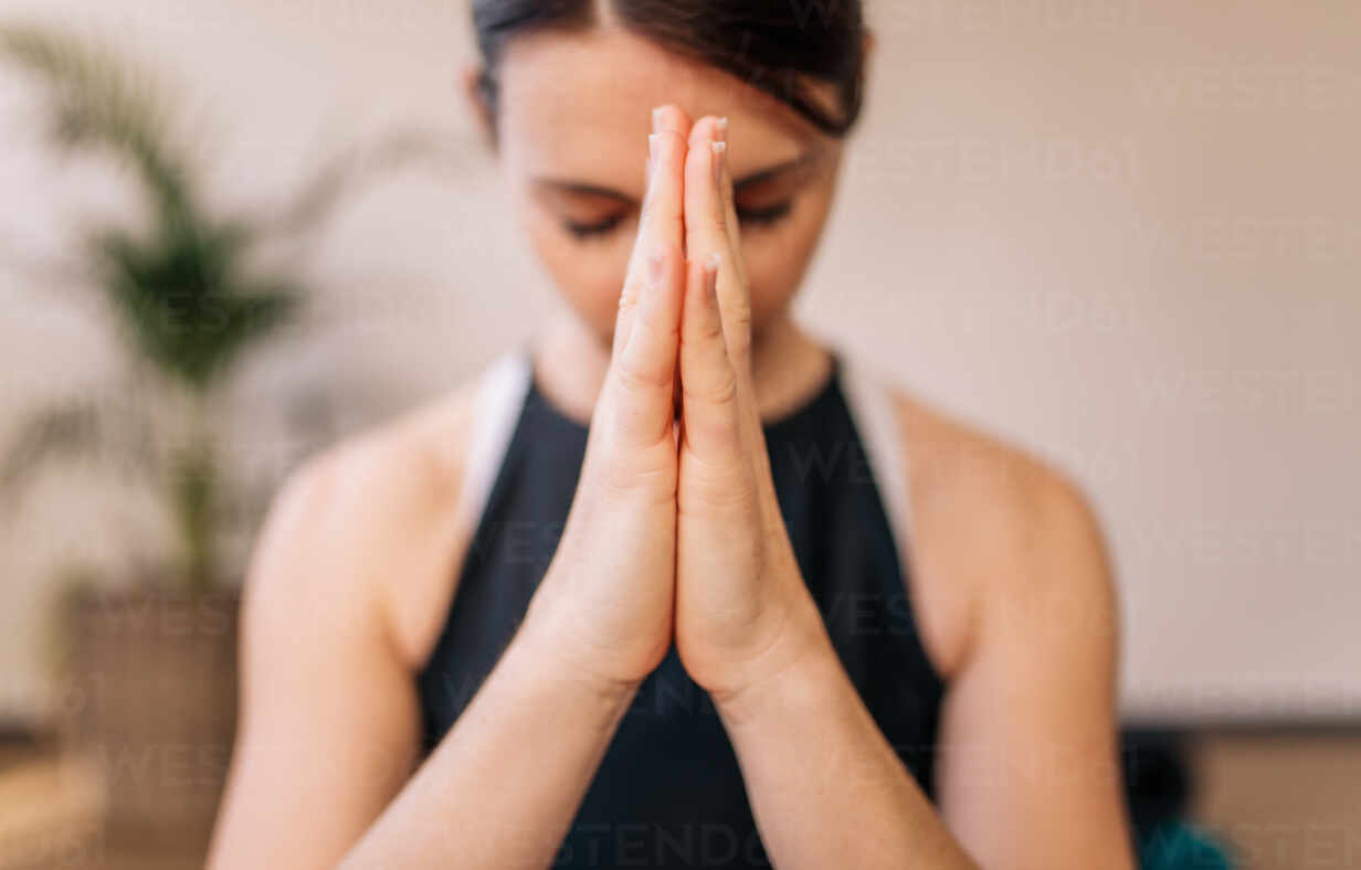 African young woman doing namaste yoga pose - a Royalty Free Stock