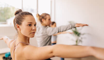 Fitness-Leute beim Yoga. Frauen beim Yoga-Kurs. Virabhadrasana-Pose. - JLPSF03146