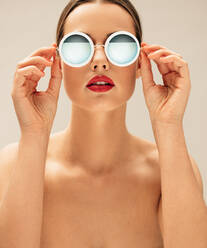 Nahaufnahme eines weiblichen Modells ohne Hemd mit Sonnenbrille. Schöne junge Frau posiert mit Brille. - JLPSF03264