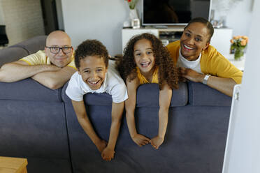Glückliche Kinder mit Eltern auf dem Sofa zu Hause - VIVF00005