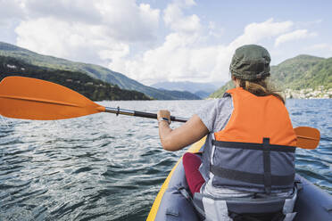 Mature woman paddling kayak in lake - UUF27487