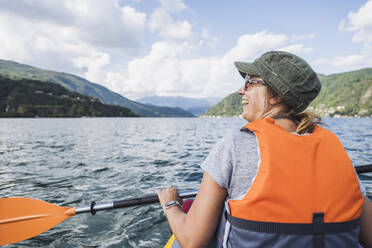 Happy mature woman kayaking at lake - UUF27509