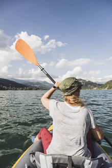 Frau beim Kajakfahren auf dem See an einem sonnigen Tag - UUF27511