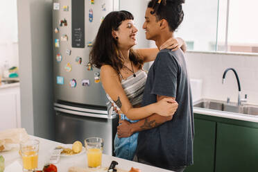 Attractive young couple sharing a romantic moment together at home. Shot of a romantic young couple smiling cheerfully while dancing together in the kitchen. Couple tango dancing at home. - JLPSF03451