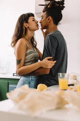Nettes Paar, das sich in der Küche umarmt. Junges, zärtliches Paar, das sich umarmt, während es zu Hause zusammensteht. Paar, das einen romantischen Moment zu Hause teilt. - JLPSF03457