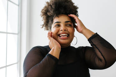 Closeup of a cheerful fashionable woman. Female with curly hair looking away and smiling. - JLPSF03553