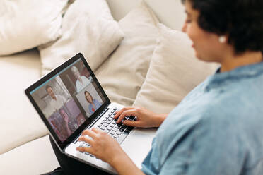 Woman having a video chat with her family and friends. Woman video calling family with laptop computer. - JLPSF03673