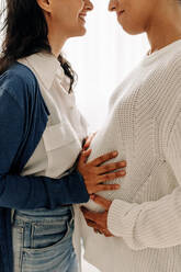 Young, diverse pregnant women in the third trimester stand