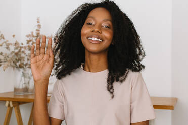 Woman waving hand while on conference call. African young woman on online video call. - JLPSF04544