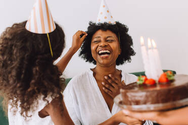 Woman smiling while her birthday celebration at home with daughter. Cheerful woman celebration her birthday at home. - JLPSF04638