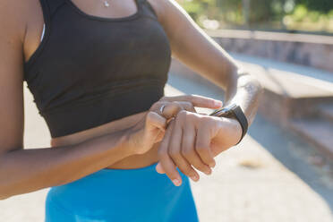 Junge Sportlerin prüft intelligente Uhr - MEUF08227