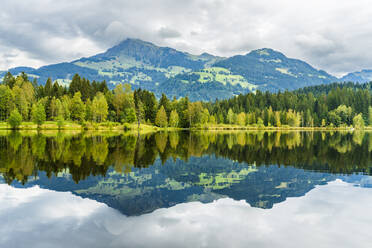 Austria, Tyrol, Lake Schwarzsee reflecting surrounding forest - STSF03535