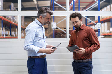 Älterer Geschäftsmann mit Kollege diskutiert über Tablet-PC in der Industrie - JOSEF13833