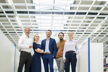 Happy businessman with colleagues standing together at industry - JOSEF13885