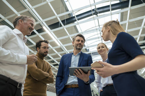 Young businesswoman discussing with colleagues in meeting at industry - JOSEF13957