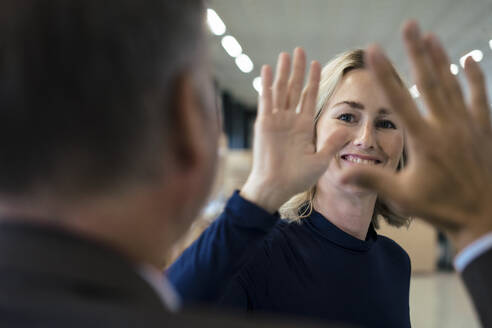 Happy businesswoman giving high-five to colleague - JOSEF13981